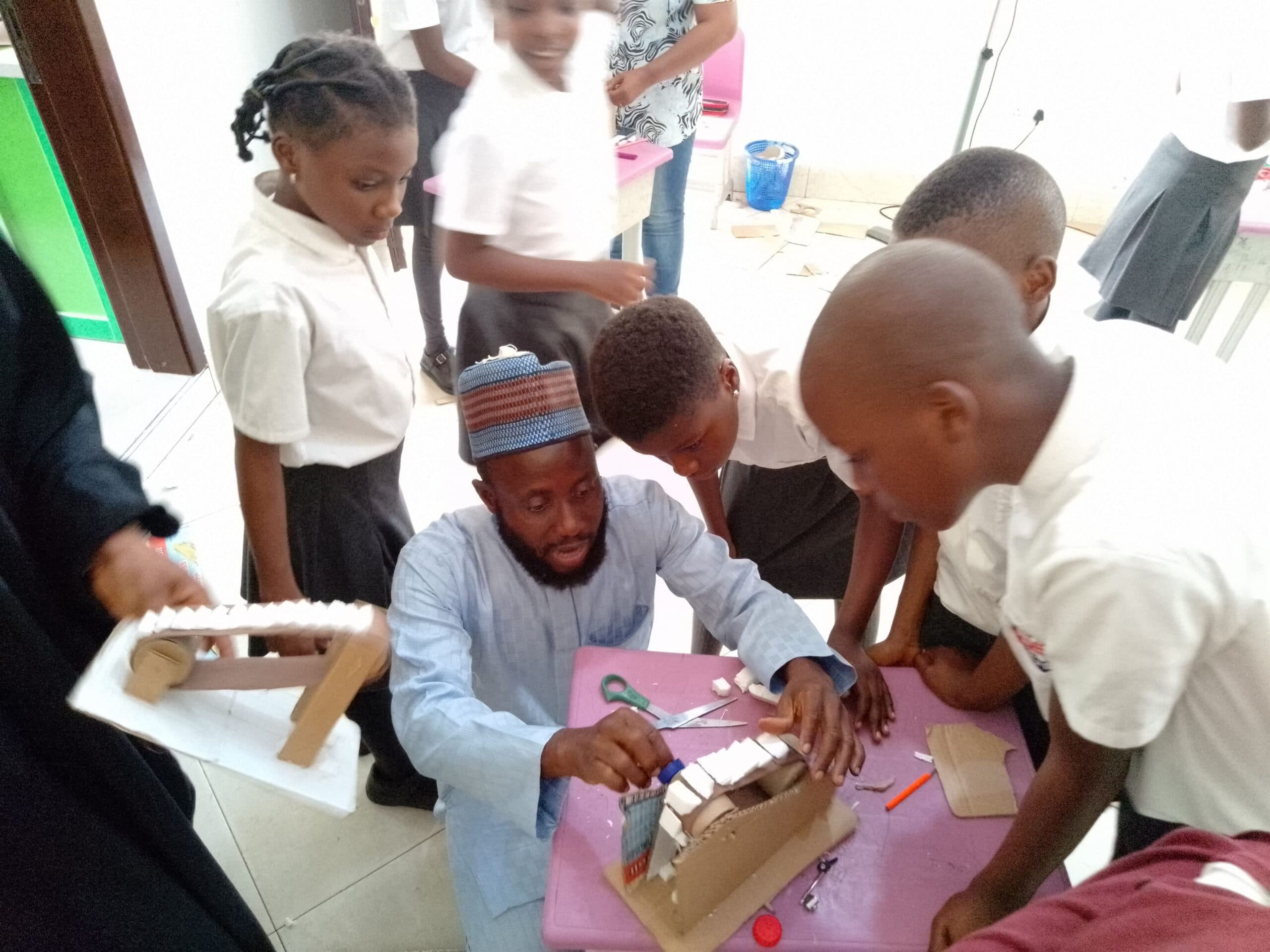 Pupils and their teacher during a hands-on learning activity at Creative Kids Academy